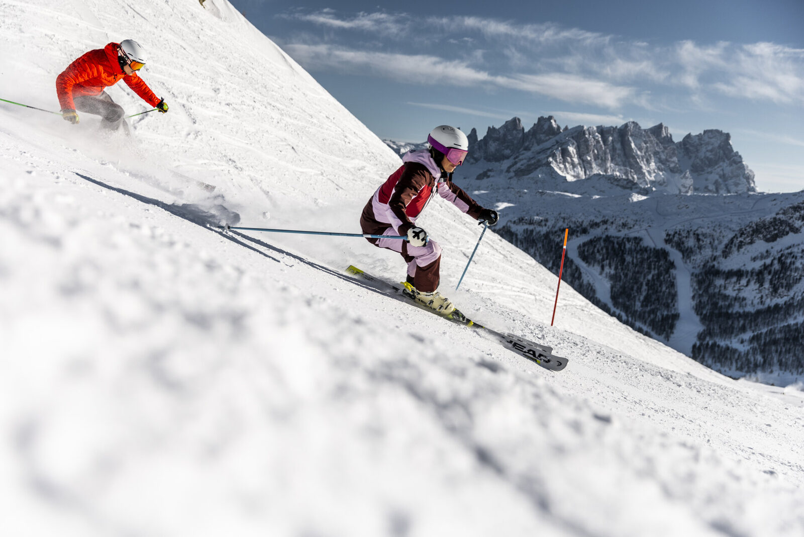 Sciatori in azione con le Dolomiti innevate sullo sfondo Val di Fassa